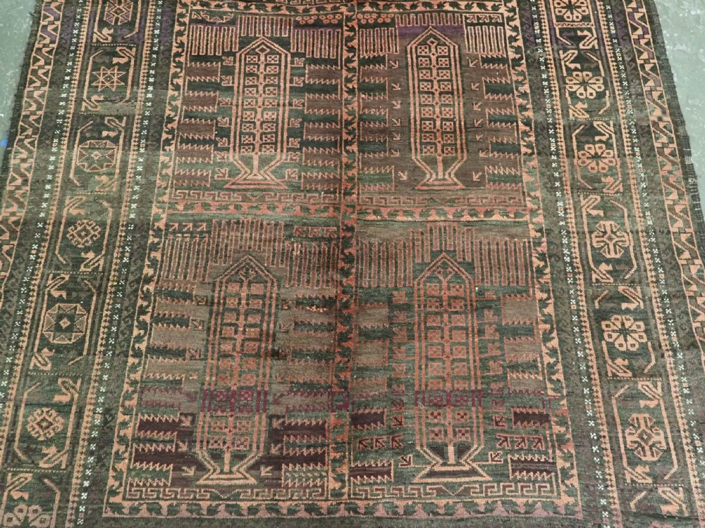 A long, dark-toned hand-knotted wool rug displaying a repeating geometric pencil box motif within complex outer geometric borders. View V