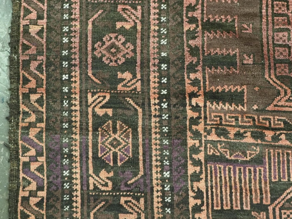 A long, dark-toned hand-knotted wool rug displaying a repeating geometric pencil box motif within complex outer geometric borders. View VIII