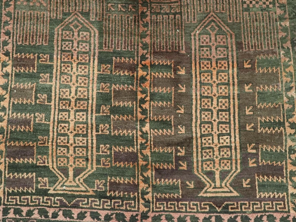 A long, dark-toned hand-knotted wool rug displaying a repeating geometric pencil box motif within complex outer geometric borders. View IX