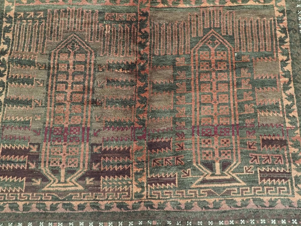 A long, dark-toned hand-knotted wool rug displaying a repeating geometric pencil box motif within complex outer geometric borders. View XII