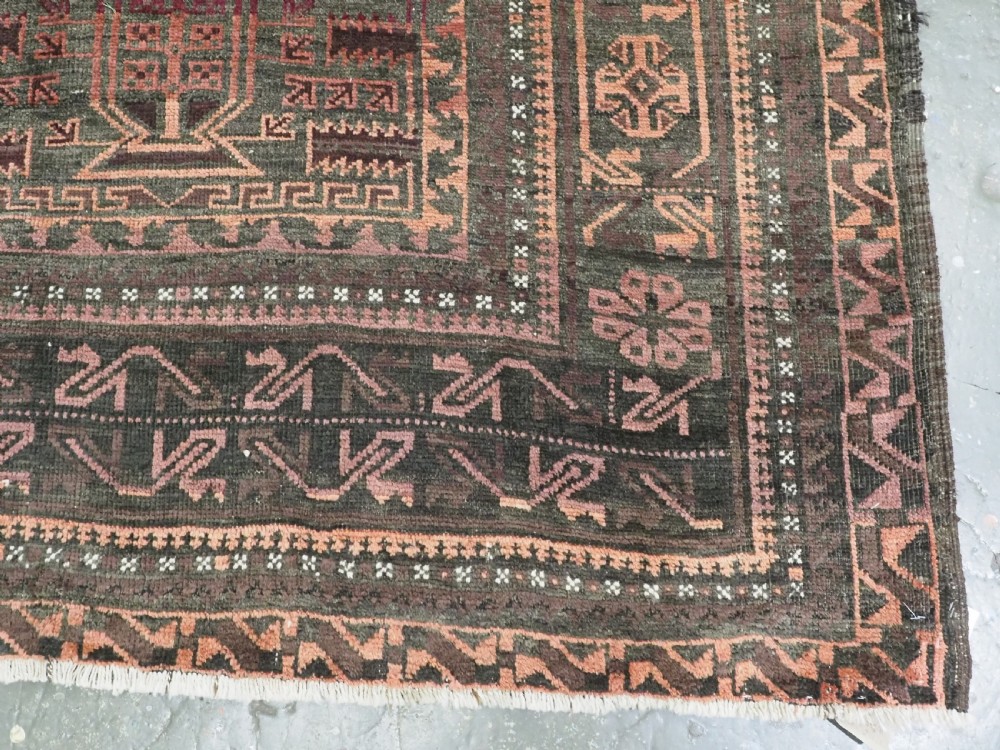 A long, dark-toned hand-knotted wool rug displaying a repeating geometric pencil box motif within complex outer geometric borders. View XIII
