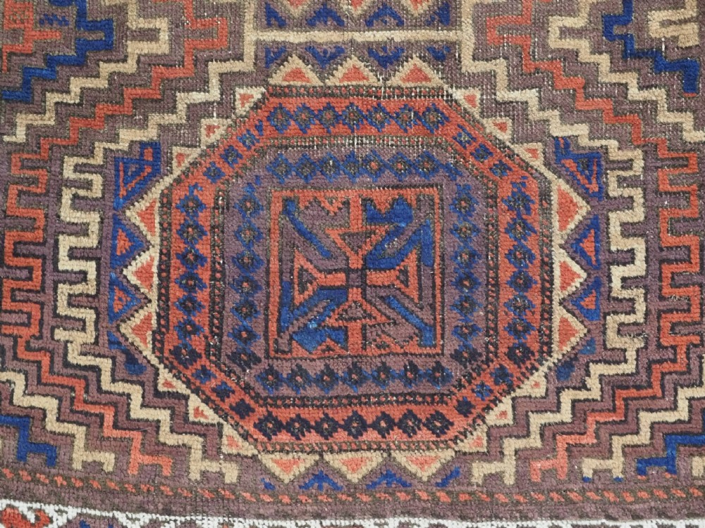 An antique hand-knotted wool rug featuring four central octagonal guls framed by stepped geometric borders in dark brown, terracotta, blue, and cream hues. View XI
