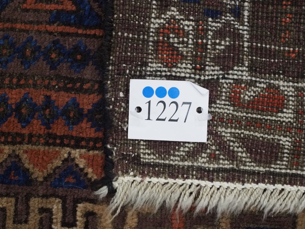 An antique hand-knotted wool rug featuring four central octagonal guls framed by stepped geometric borders in dark brown, terracotta, blue, and cream hues. View XIV