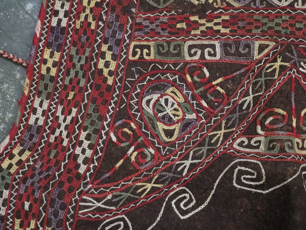 An antique Yomut Turkmen dark brown felt horse blanket featuring intricate red, cream, and green geometric embroidered borders, central spiral scroll motifs, and top corner tassels. View VI