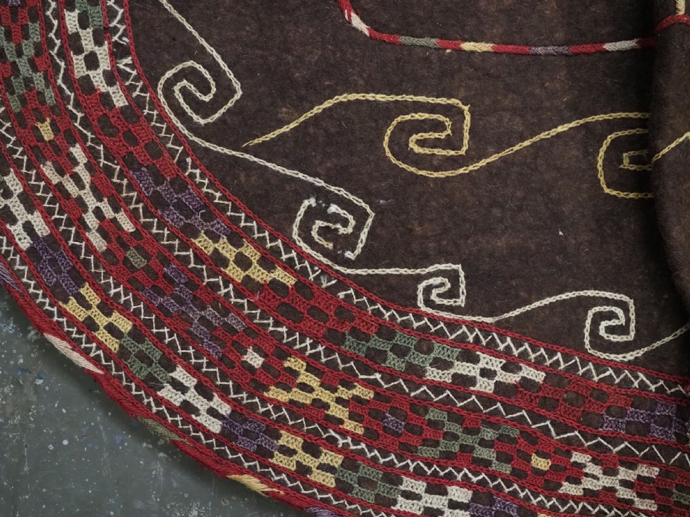 An antique Yomut Turkmen dark brown felt horse blanket featuring intricate red, cream, and green geometric embroidered borders, central spiral scroll motifs, and top corner tassels. View XIII