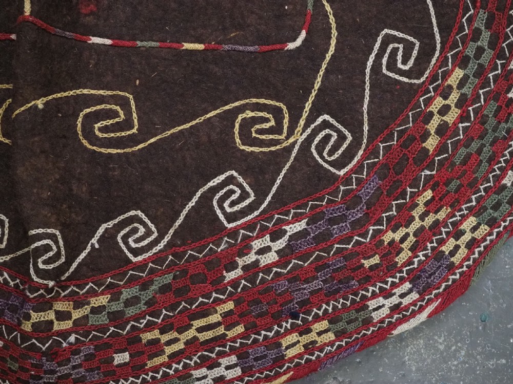 An antique Yomut Turkmen dark brown felt horse blanket featuring intricate red, cream, and green geometric embroidered borders, central spiral scroll motifs, and top corner tassels. View XIV