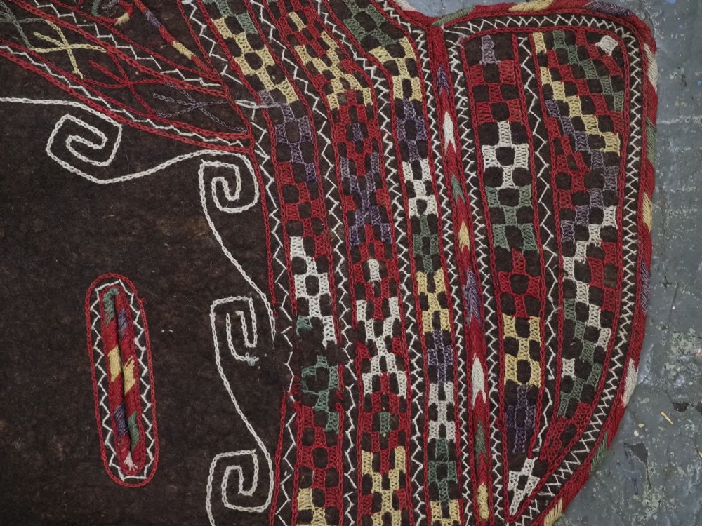 An antique Yomut Turkmen dark brown felt horse blanket featuring intricate red, cream, and green geometric embroidered borders, central spiral scroll motifs, and top corner tassels. View XV