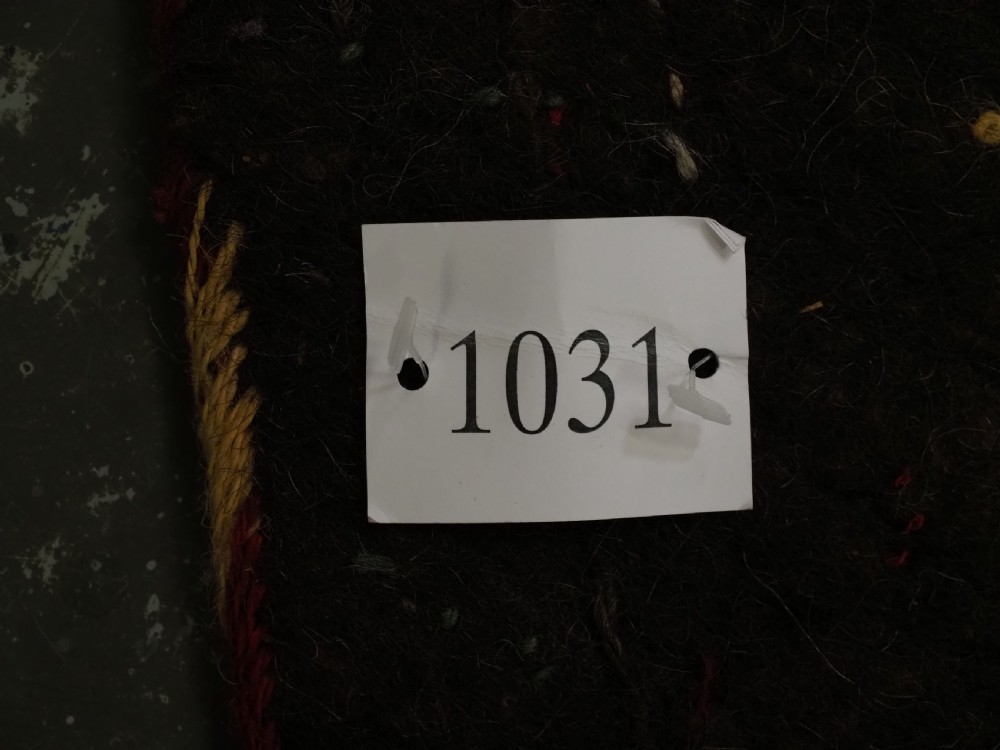 An antique Yomut Turkmen dark brown felt horse blanket featuring intricate red, cream, and green geometric embroidered borders, central spiral scroll motifs, and top corner tassels. View XVIII