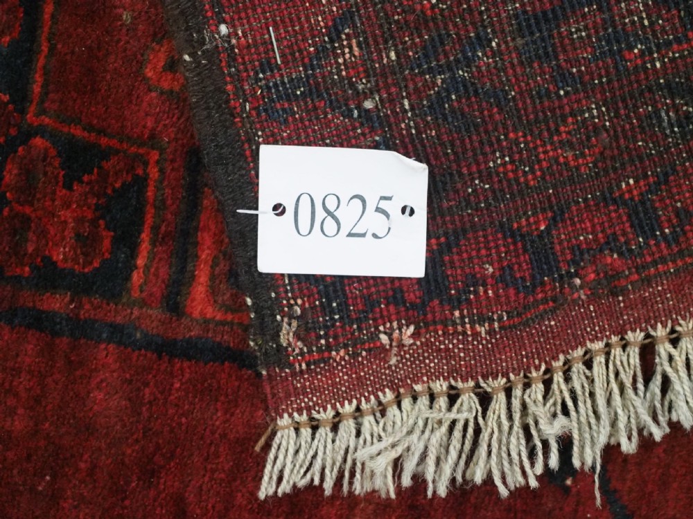 An antique hand-knotted Afghan Ersari wool carpet featuring dark blue octagonal gul motifs arranged in rows on a warm red field. View XIII