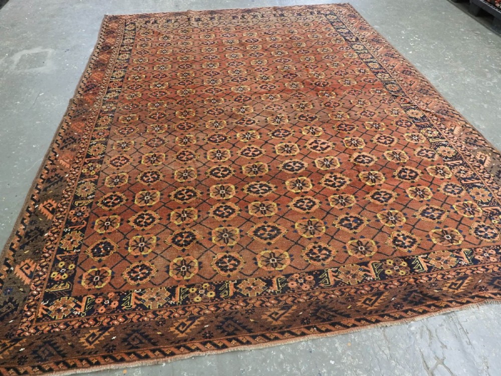 An antique Afghan Ersari Turkmen hand-knotted wool carpet featuring a repeating lattice grid with rosettes in terracotta red, dark blue, and yellow accents. View II