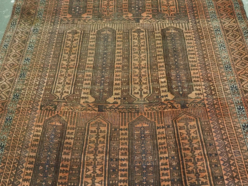 An antique Afghan Baluch hand-knotted wool carpet featuring repeating vertical geometric motifs in terracotta, dark brown, and rust tones. View V