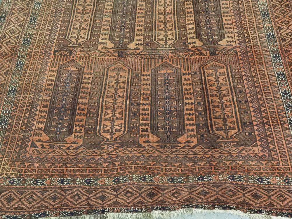 An antique Afghan Baluch hand-knotted wool carpet featuring repeating vertical geometric motifs in terracotta, dark brown, and rust tones. View VI