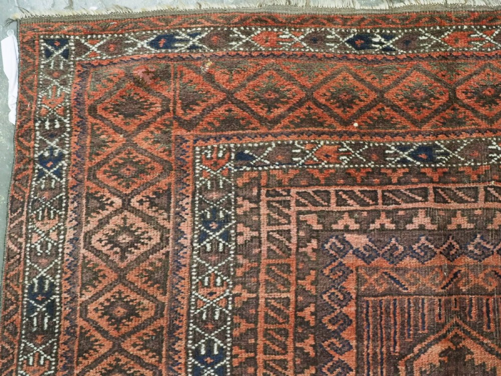 An antique Afghan Baluch hand-knotted wool carpet featuring repeating vertical geometric motifs in terracotta, dark brown, and rust tones. View VII