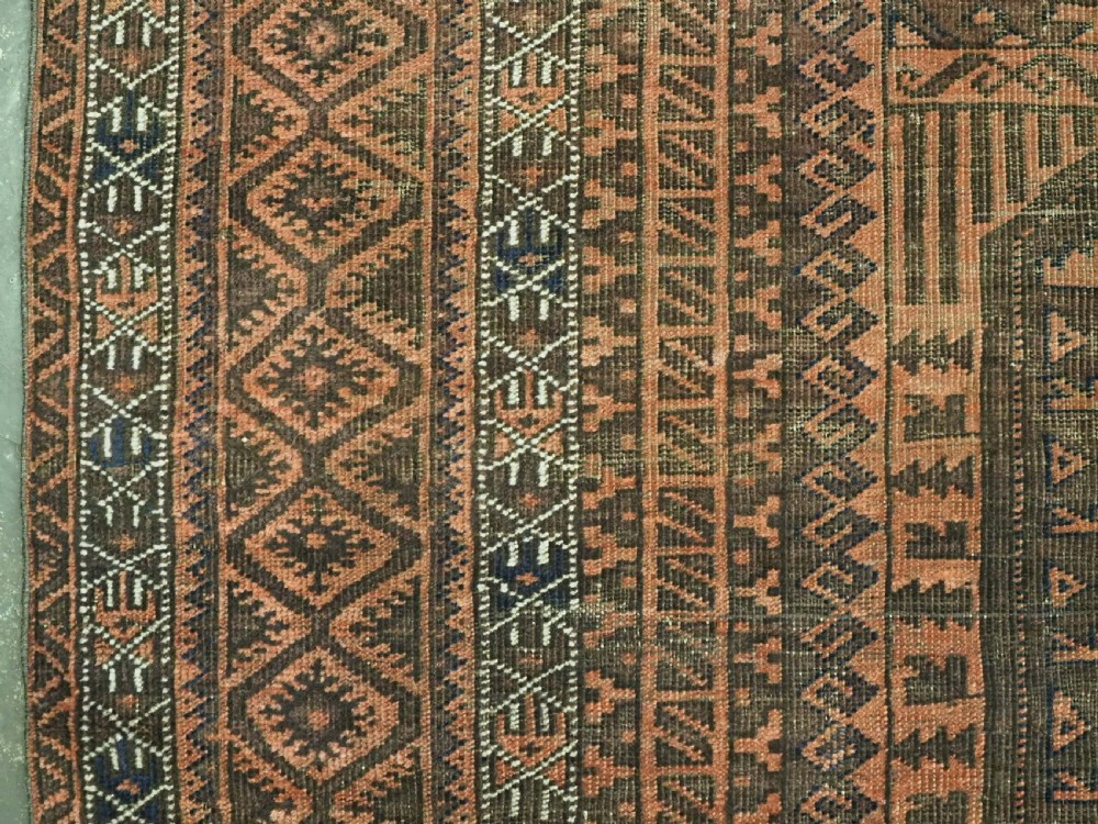 An antique Afghan Baluch hand-knotted wool carpet featuring repeating vertical geometric motifs in terracotta, dark brown, and rust tones. View VIII
