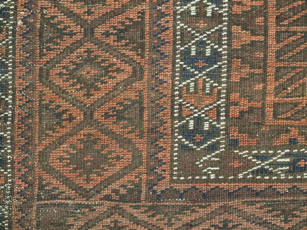 An antique Afghan Baluch hand-knotted wool carpet featuring repeating vertical geometric motifs in terracotta, dark brown, and rust tones. View XIV
