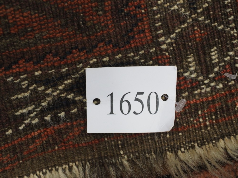 An antique Afghan Baluch hand-knotted wool carpet featuring repeating vertical geometric motifs in terracotta, dark brown, and rust tones. View XV