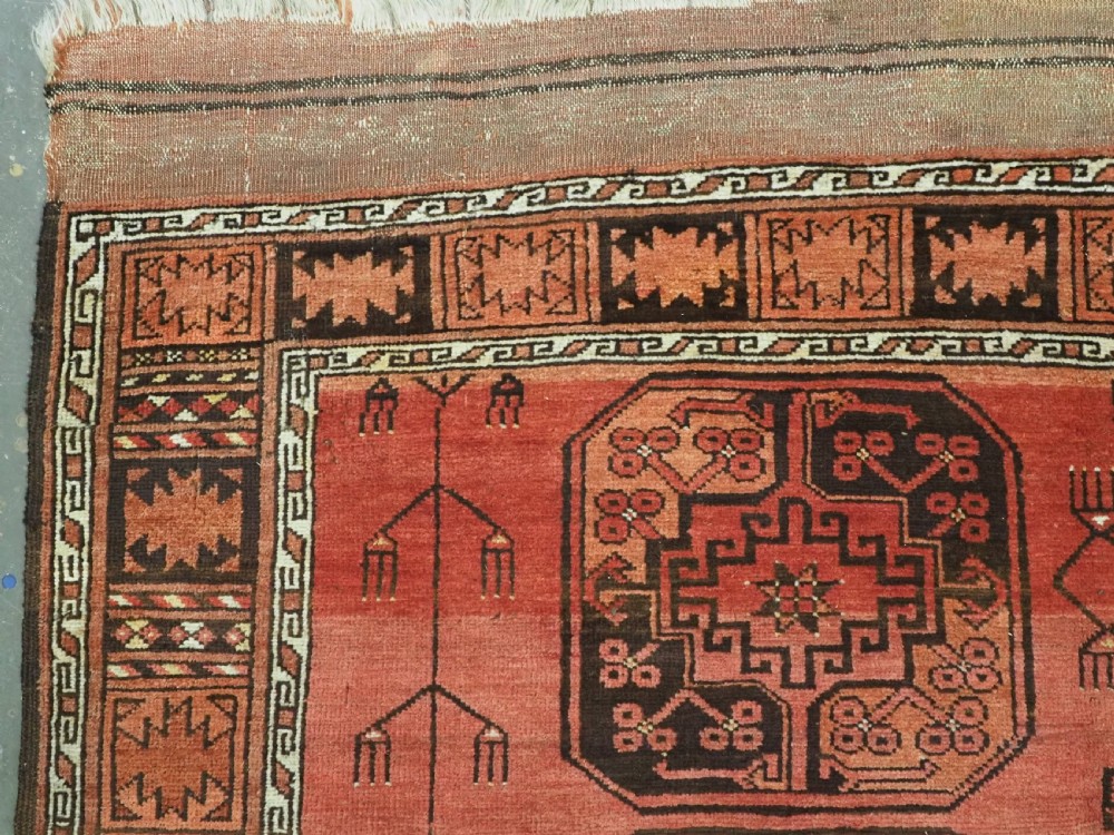 An antique Ersari Turkmen carpet from circa 1890 featuring repeating octagonal guls across a deep terracotta red wool field with geometric borders. View VI