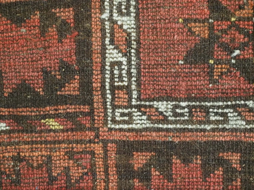 An antique Ersari Turkmen carpet from circa 1890 featuring repeating octagonal guls across a deep terracotta red wool field with geometric borders. View XIV