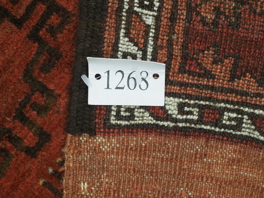 An antique Ersari Turkmen carpet from circa 1890 featuring repeating octagonal guls across a deep terracotta red wool field with geometric borders. View XV