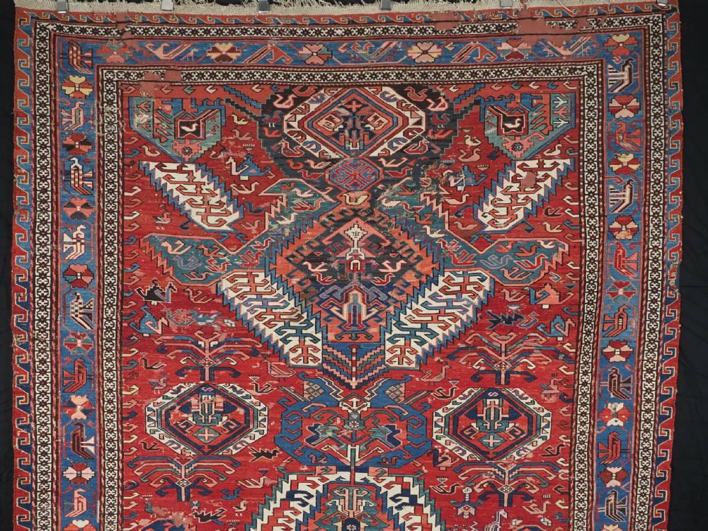 An antique hand-woven Caucasian Soumak flatweave rug featuring a red ground with geometric dragon medallions and a patterned border. View II