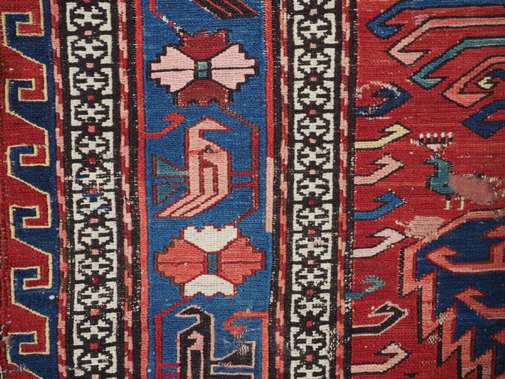 An antique hand-woven Caucasian Soumak flatweave rug featuring a red ground with geometric dragon medallions and a patterned border. View VI