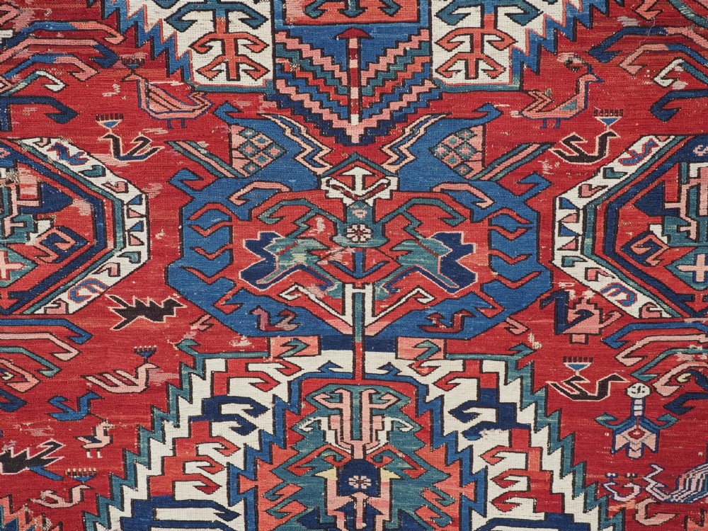 An antique hand-woven Caucasian Soumak flatweave rug featuring a red ground with geometric dragon medallions and a patterned border. View IX