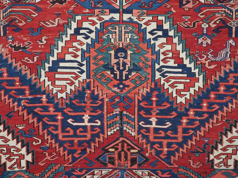 An antique hand-woven Caucasian Soumak flatweave rug featuring a red ground with geometric dragon medallions and a patterned border. View X