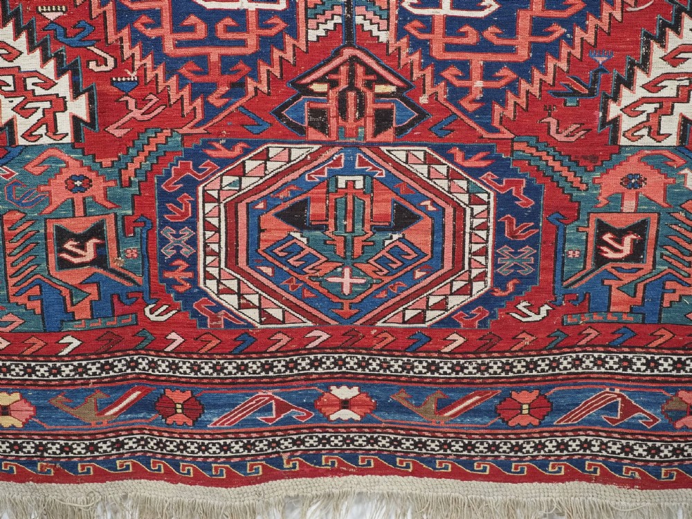 An antique hand-woven Caucasian Soumak flatweave rug featuring a red ground with geometric dragon medallions and a patterned border. View XI