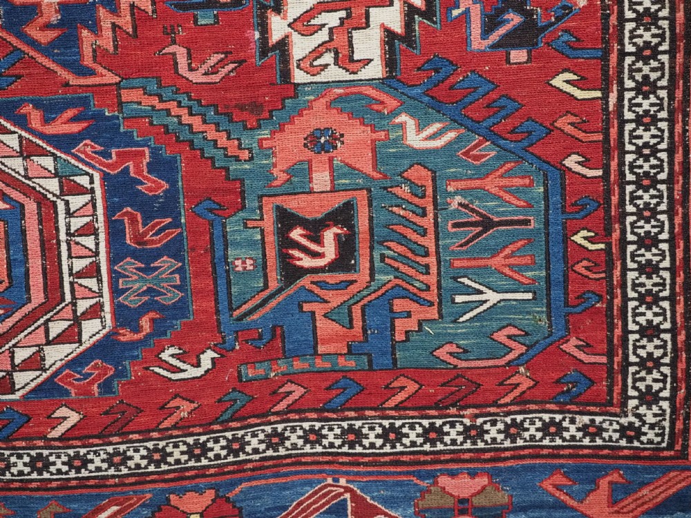 An antique hand-woven Caucasian Soumak flatweave rug featuring a red ground with geometric dragon medallions and a patterned border. View XII