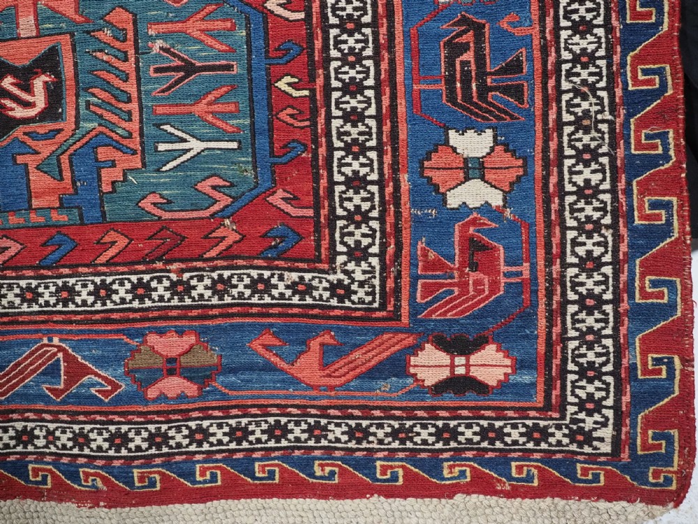 An antique hand-woven Caucasian Soumak flatweave rug featuring a red ground with geometric dragon medallions and a patterned border. View XIII
