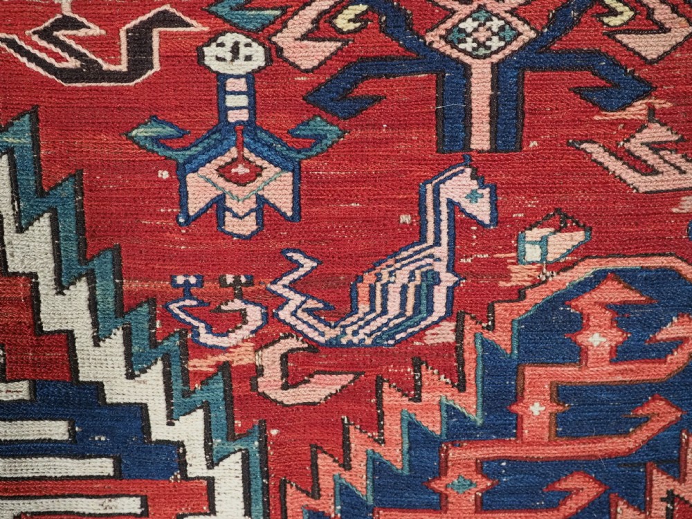 An antique hand-woven Caucasian Soumak flatweave rug featuring a red ground with geometric dragon medallions and a patterned border. View XIV
