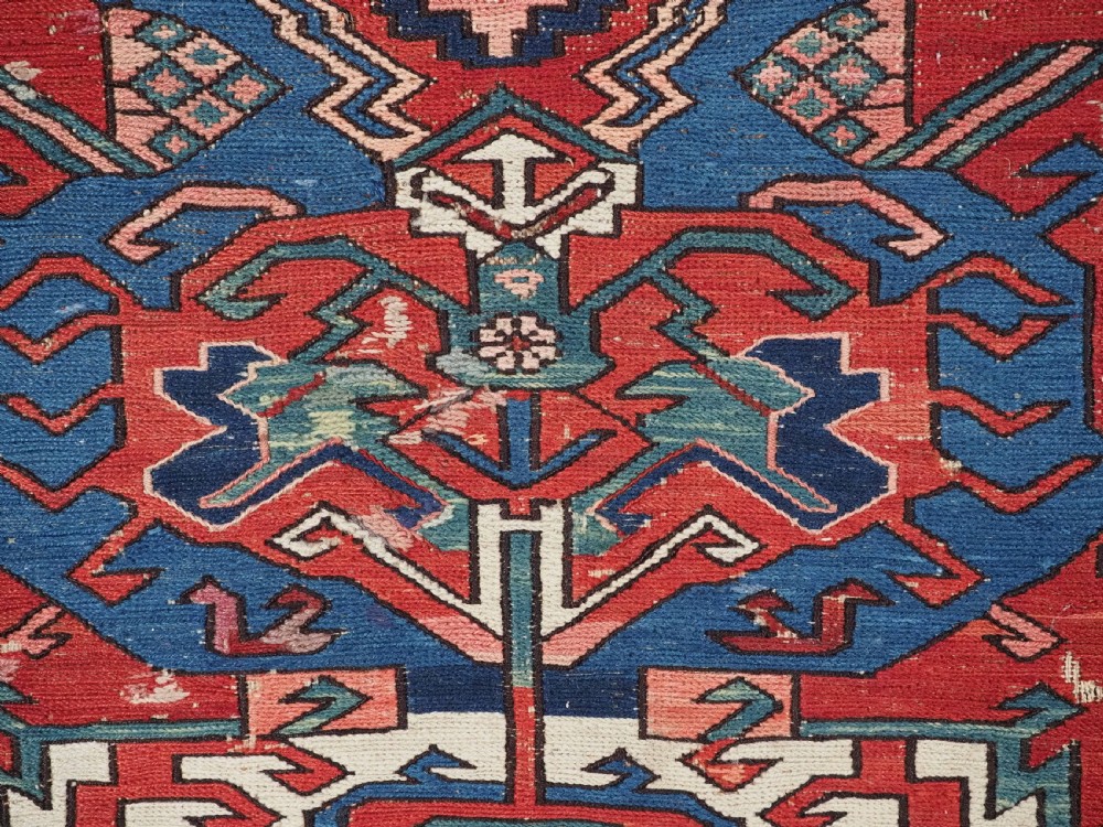 An antique hand-woven Caucasian Soumak flatweave rug featuring a red ground with geometric dragon medallions and a patterned border. View XV