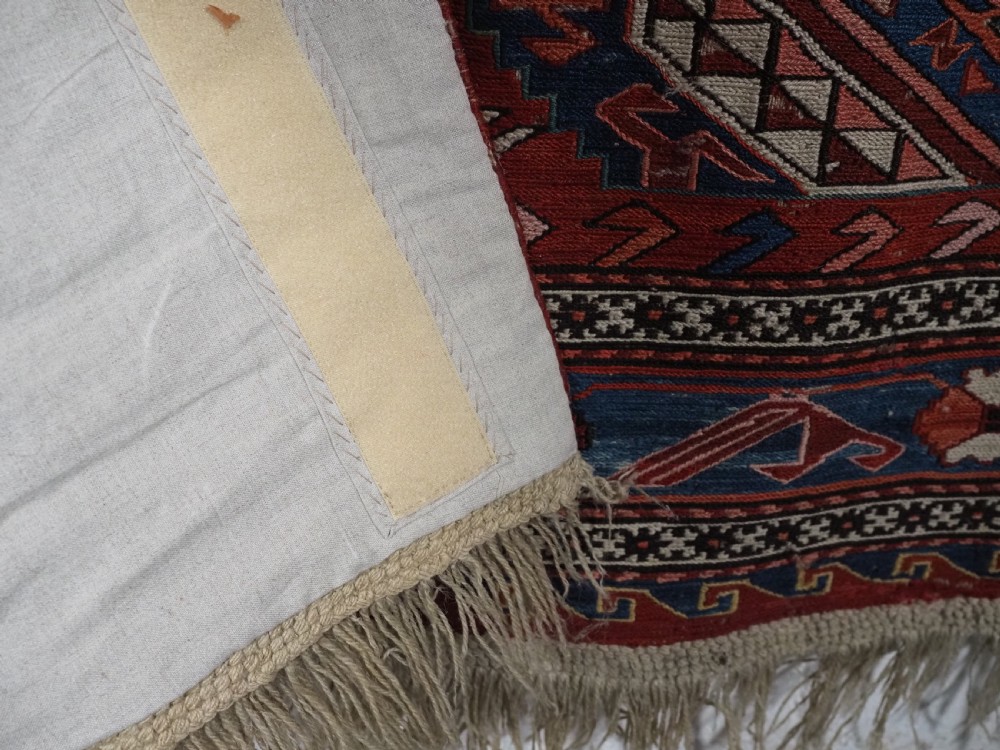 An antique hand-woven Caucasian Soumak flatweave rug featuring a red ground with geometric dragon medallions and a patterned border. View XVI