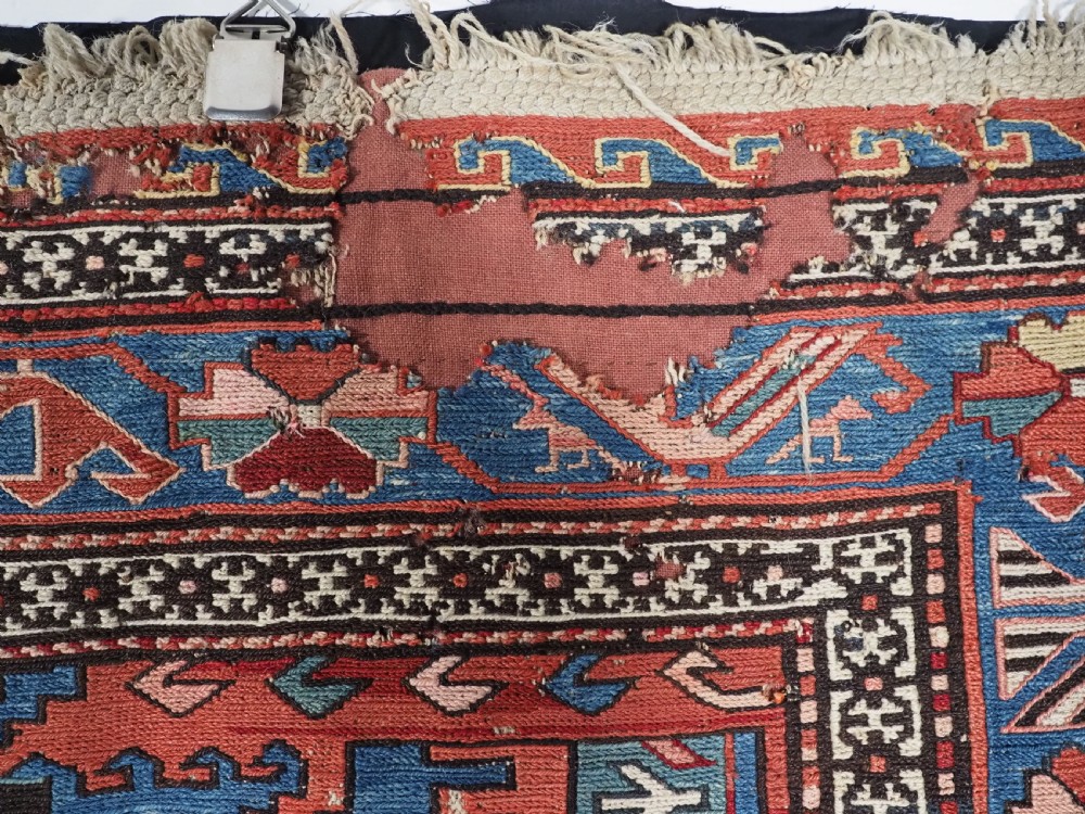 An antique hand-woven Caucasian Soumak flatweave rug featuring a red ground with geometric dragon medallions and a patterned border. View XVII