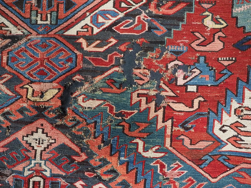 An antique hand-woven Caucasian Soumak flatweave rug featuring a red ground with geometric dragon medallions and a patterned border. View XX