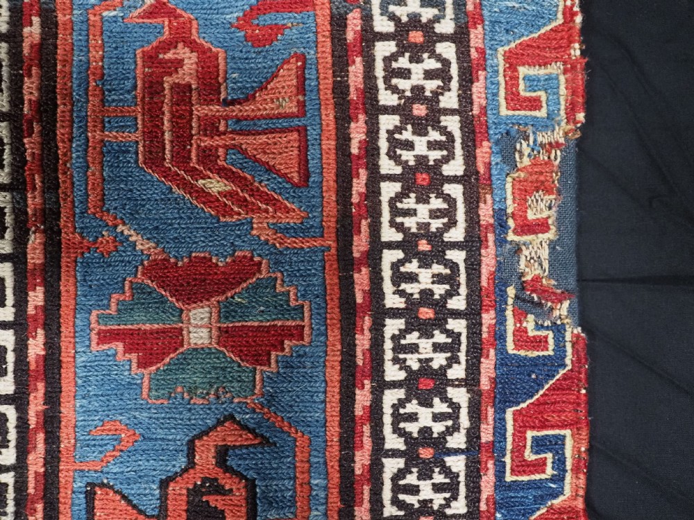 An antique hand-woven Caucasian Soumak flatweave rug featuring a red ground with geometric dragon medallions and a patterned border. View XXI