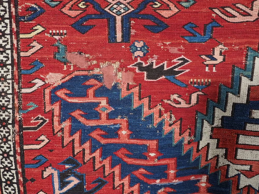 An antique hand-woven Caucasian Soumak flatweave rug featuring a red ground with geometric dragon medallions and a patterned border. View XXII