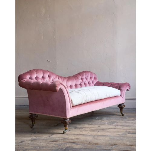 fig 1. A Victorian deep-buttoned rose pink velvet chaise longue featuring carved mahogany Ionic column legs on brass castors with a loose white seat cushion.