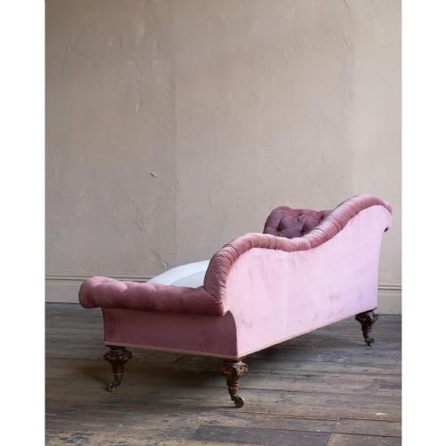 fig 2. A Victorian deep-buttoned rose pink velvet chaise longue featuring carved mahogany Ionic column legs on brass castors with a loose white seat cushion.