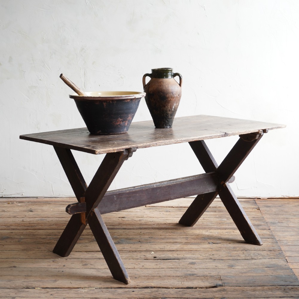A rustic dark timber tavern table featuring an X-frame trestle base connected by a central horizontal stretcher. View V