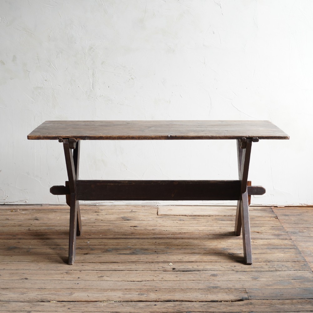 A rustic dark timber tavern table featuring an X-frame trestle base connected by a central horizontal stretcher. View IV