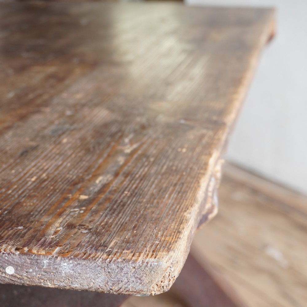 A rustic dark timber tavern table featuring an X-frame trestle base connected by a central horizontal stretcher. View VII