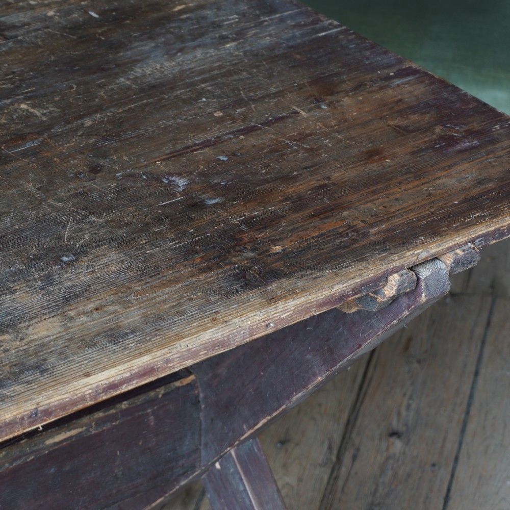 A rustic dark timber tavern table featuring an X-frame trestle base connected by a central horizontal stretcher. View IX
