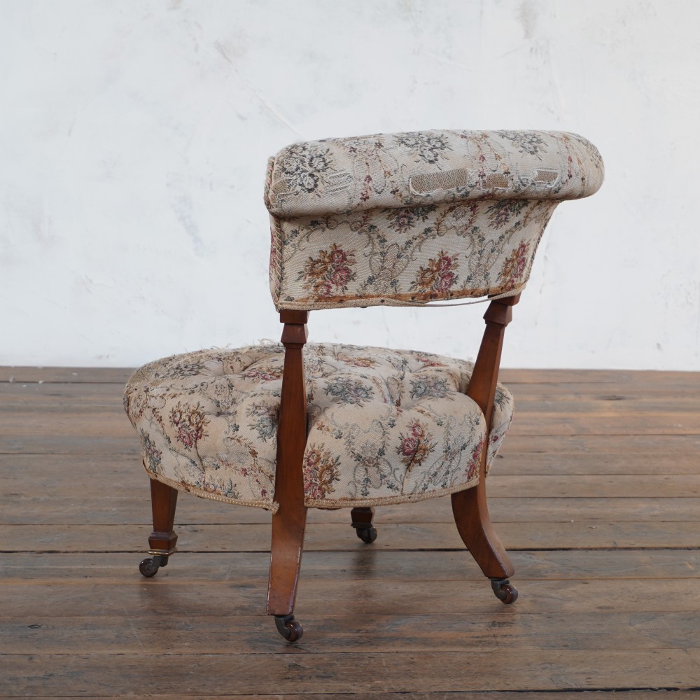 A Victorian low-seated slipper chair with deep-buttoned floral tapestry upholstery, supported by fluted front timber legs on brass castors. View III