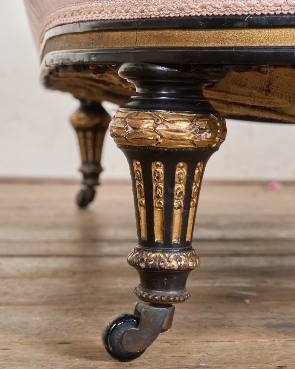 An antique Aesthetic Movement sofa upholstered in pink velvet, featuring ebonised and gilded carved legs on castors. View VI