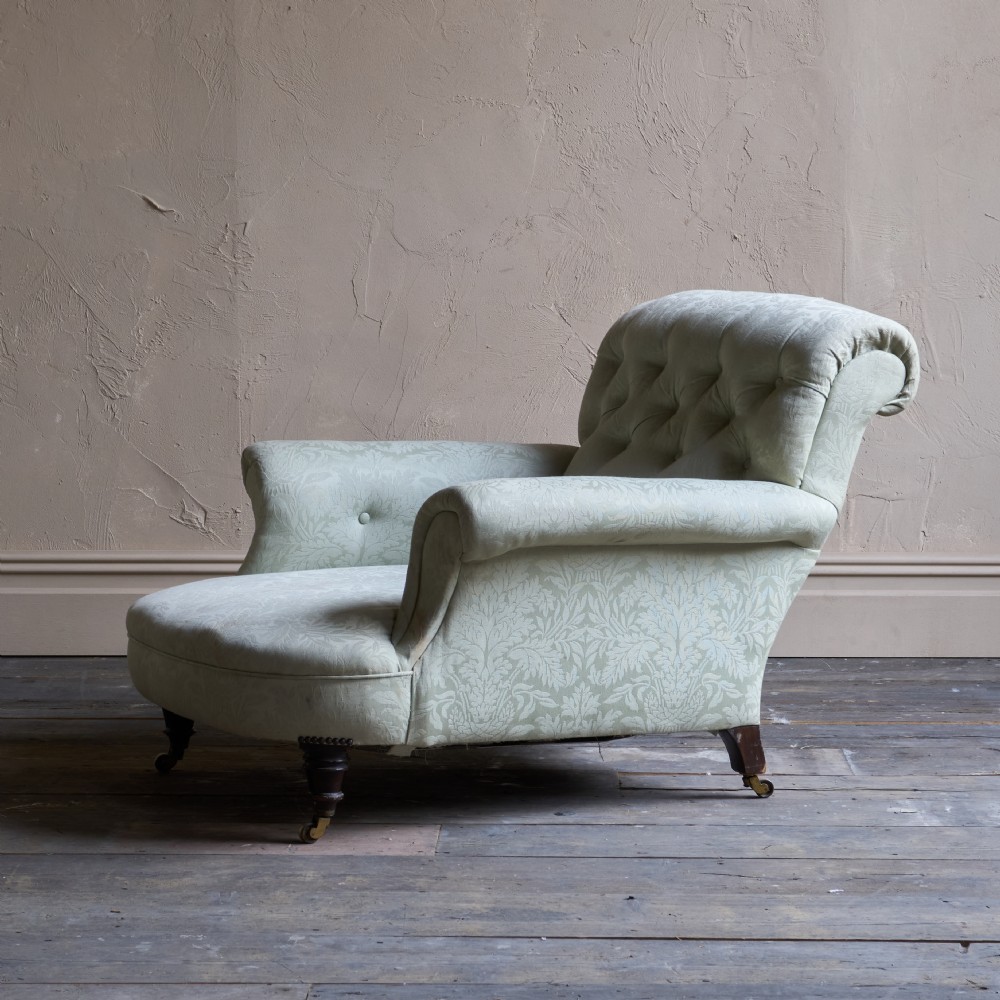 An antique sage green damask upholstered armchair with rolled arms, button tufting, and turned wooden legs with brass castors. View X