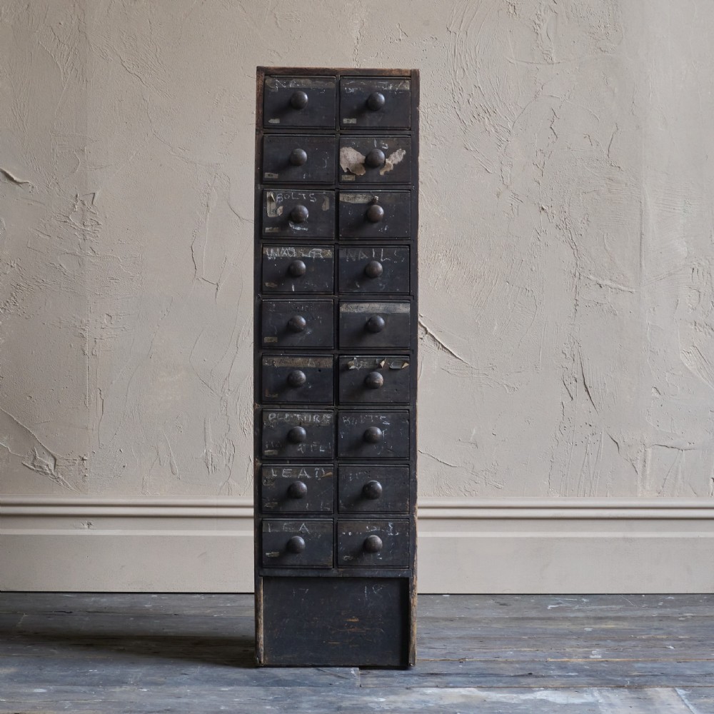 A tall and narrow antique dark wood ironmongers chest featuring sixteen small drawers with turned knobs and hand-painted white labels. View III