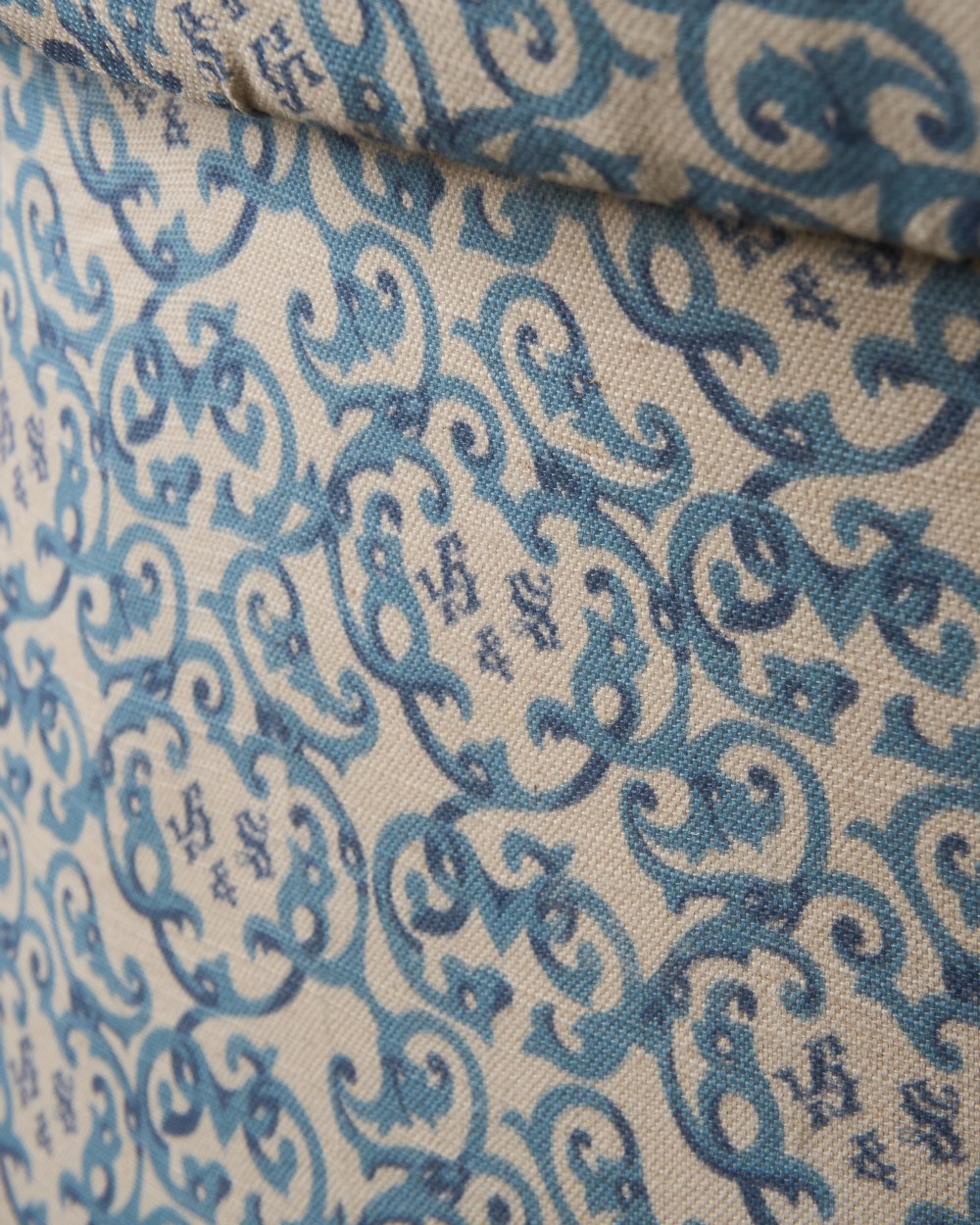 A Victorian Howard style armchair upholstered in blue and white scroll printed fabric with deep buttoning and turned mahogany legs on brass castors. View XII