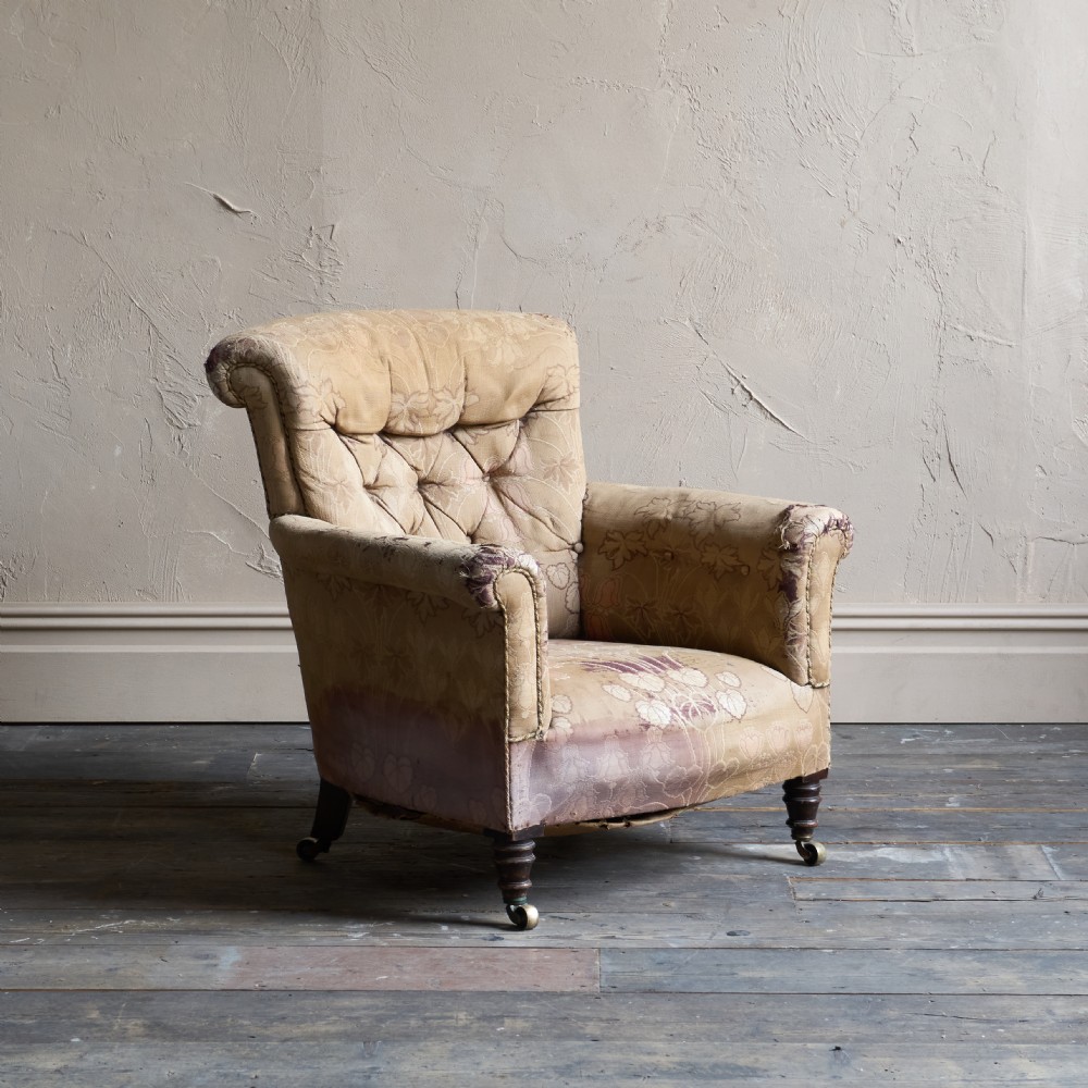 A low-seated Victorian style upholstered easy chair featuring a deep-buttoned backrest, rolled arms, floral damask pattern, and turned timber front legs with brass castors. View II