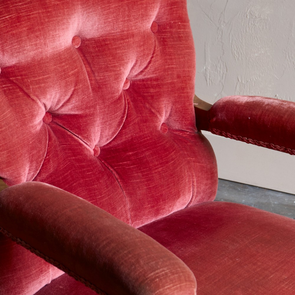 Victorian open armchair featuring deep buttoned rose pink velvet upholstery, turned wooden front legs, and brass castors. View VIII
